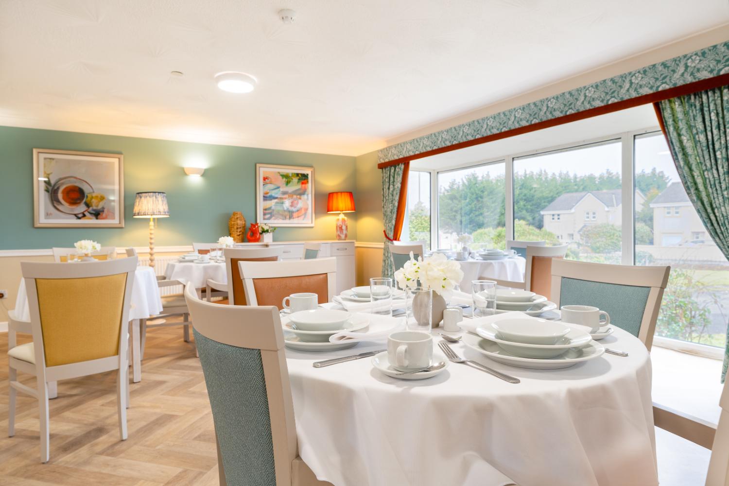 tables set for dinner in a pastel colour dining room