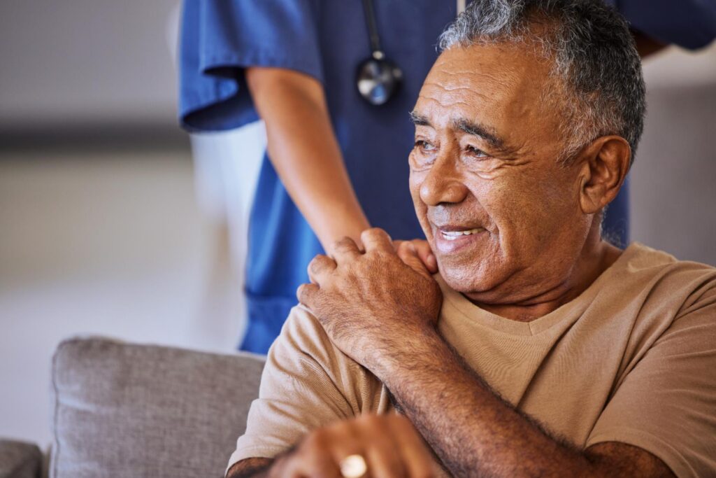 nurse with hand on residents shoulder